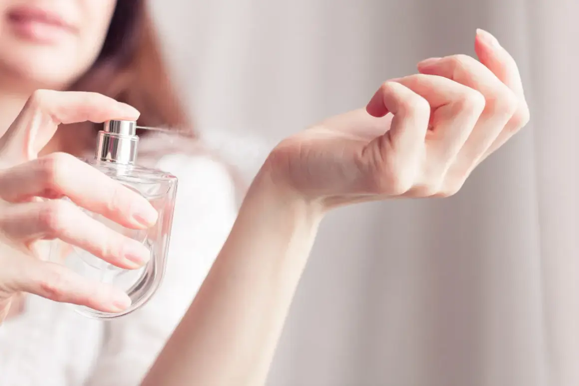 Kobieta rozpyla perfumy na nadgarstek. Zapach przypomina Niveę, otulając skórę delikatną mgiełką.