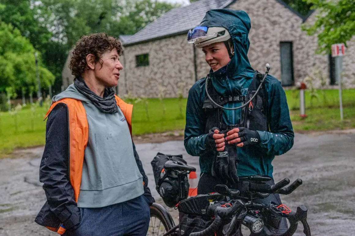 Dwie rowerzystki rozmawiają w deszczu podczas wyścigu Małopolska 500.