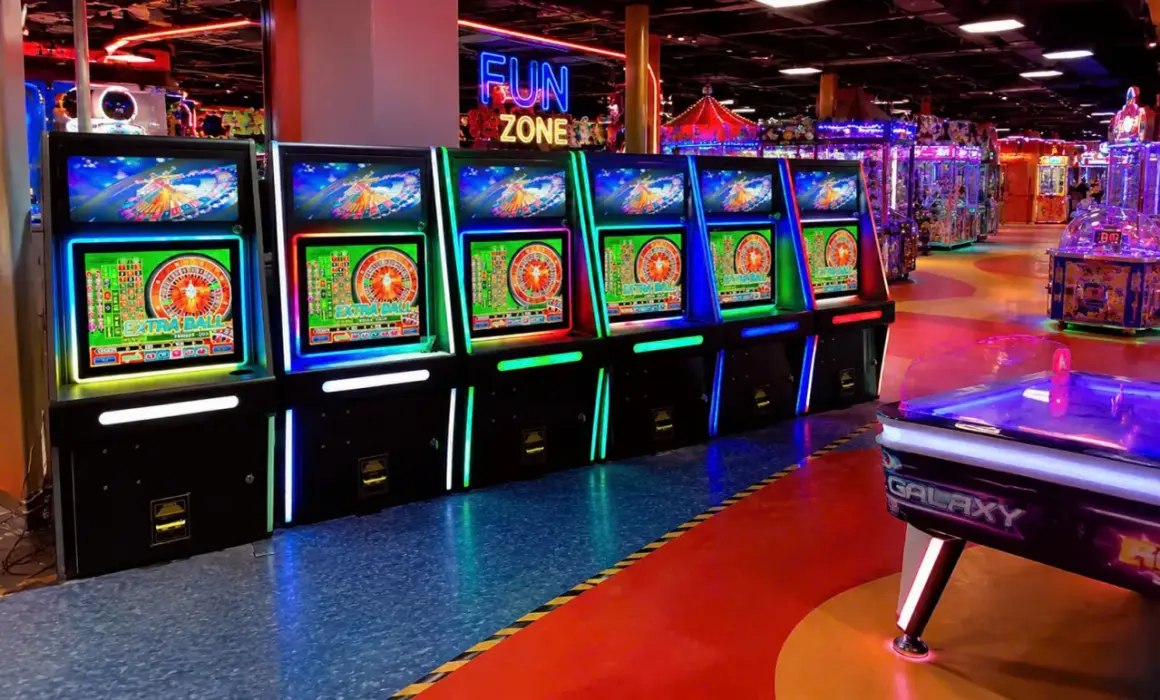 Rząd podświetlanych maszyn do gry zręcznościowej w "Fun Zone", gdzie każdy może spróbować szczęścia.