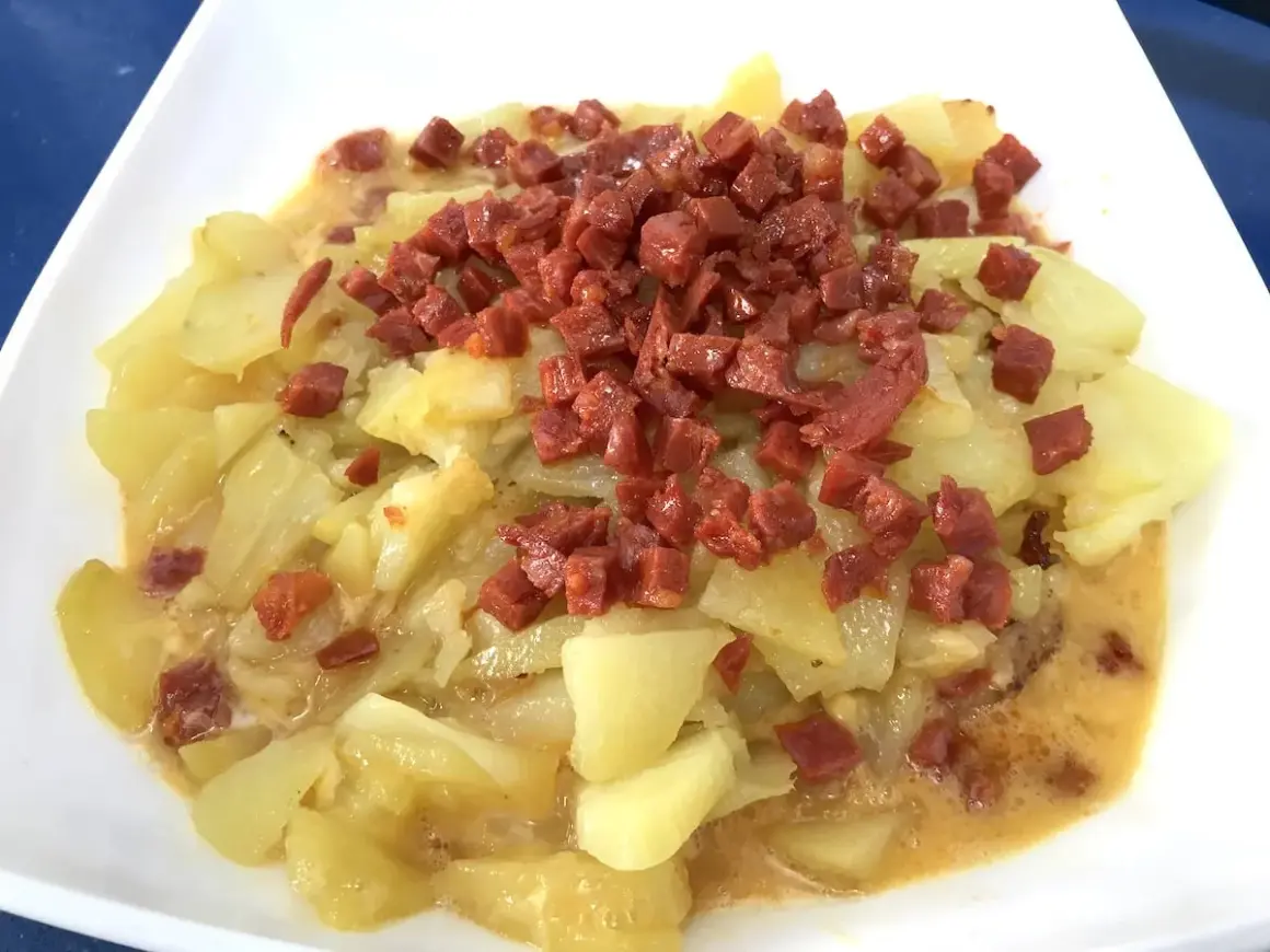 Plato de patatas con trocitos de chorizo, una deliciosa tortilla de chorizo lista para disfrutar.