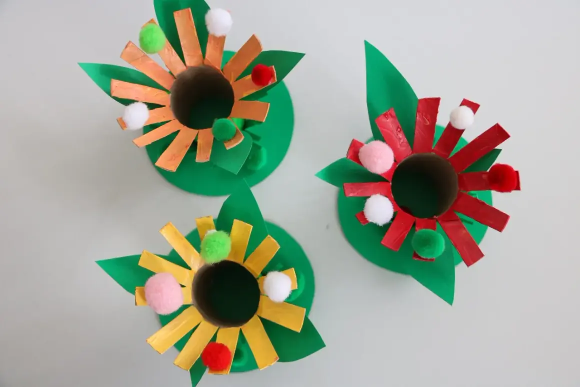Roliga pysseltips med toarullar! Tre färgglada blommor av toarullar, papper och fluffiga bollar. Perfekt för barnens pysselstund.