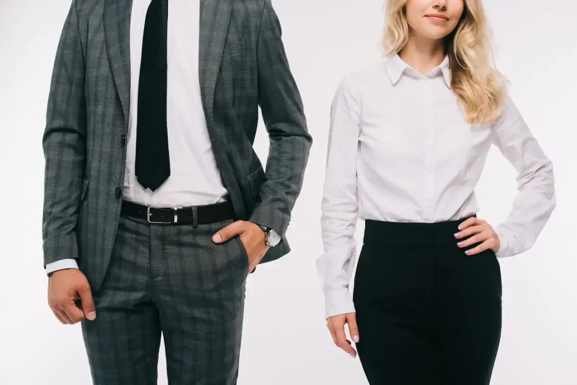 Elegancki mężczyzna w garniturze i kobieta w białej koszuli i czarnej spódnicy, prezentujący profesjonalny dress code.