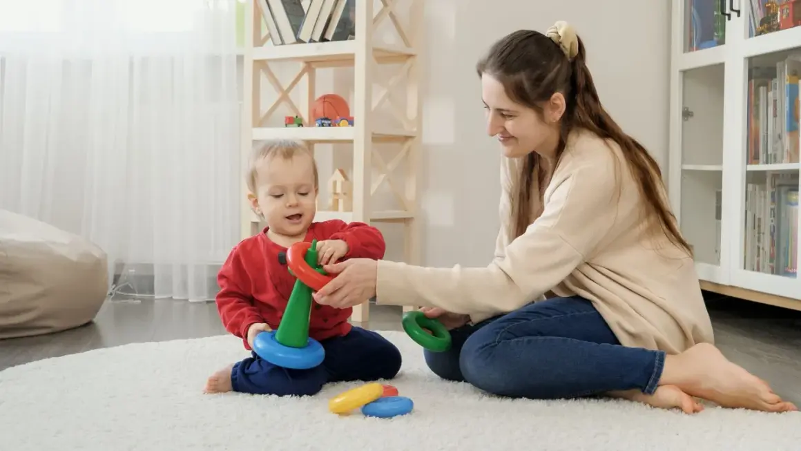 Mama i dziecko bawią się kółkami, rozwijając zdolności motoryczne. Radość i nauka w jednym.