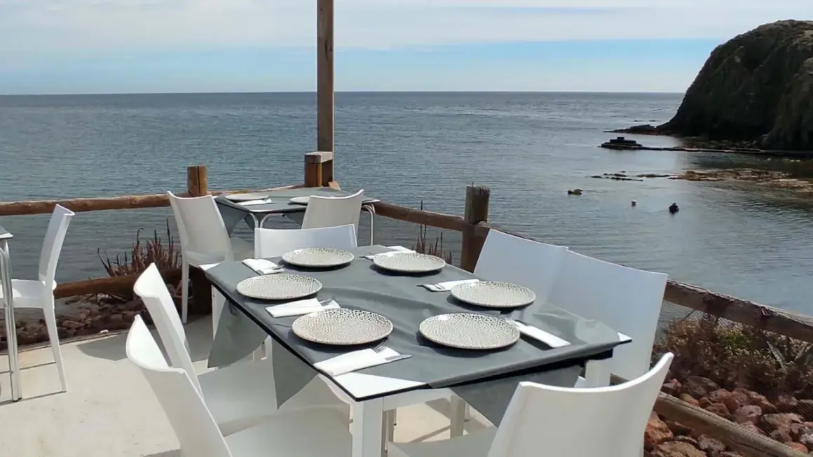 Mesas puestas en un restaurante de Almería con vistas al mar.