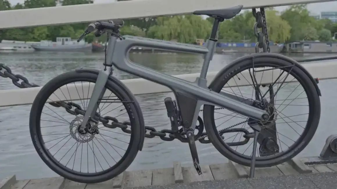Moderne, hippe stadsfiets met een uniek frame, geparkeerd op een brug met uitzicht op boten.