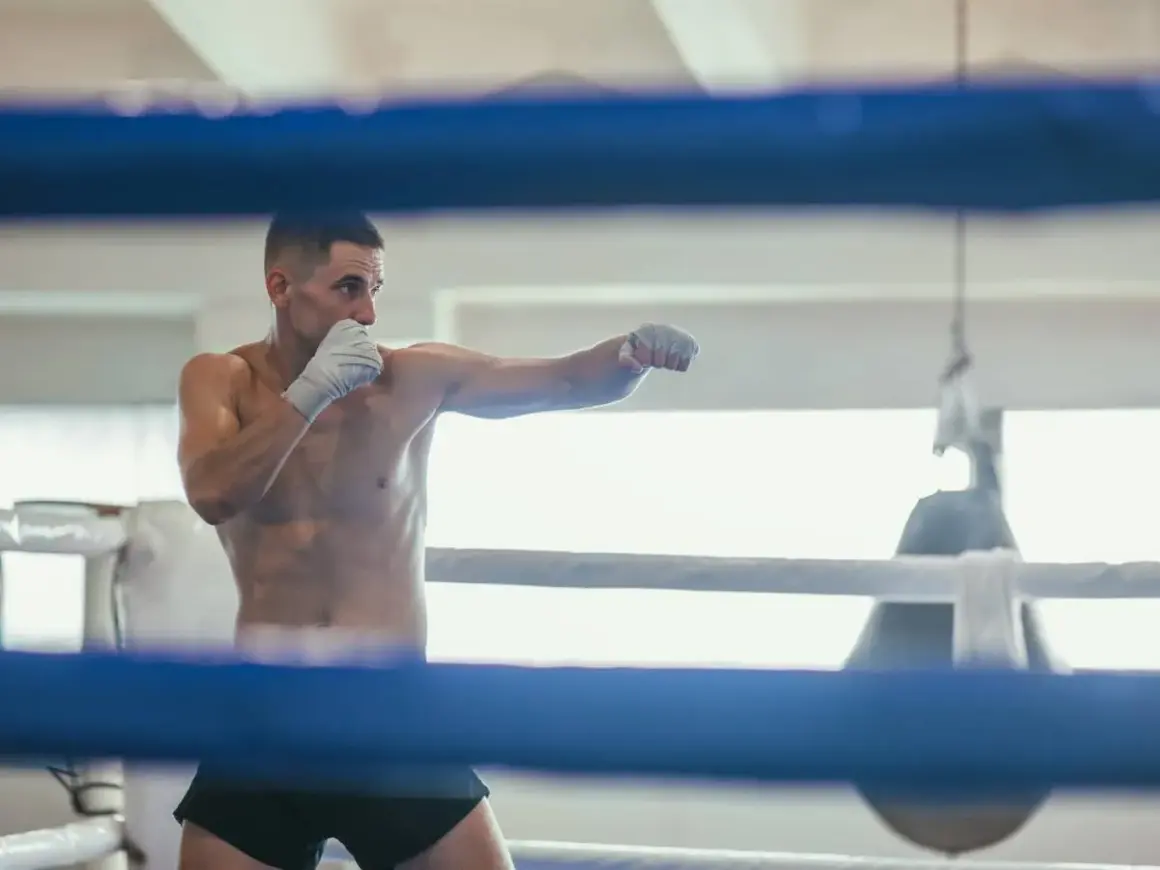 A boxer throws punches in a ring, practicing his moves. This is how shadow boxing, a training technique, likely began.