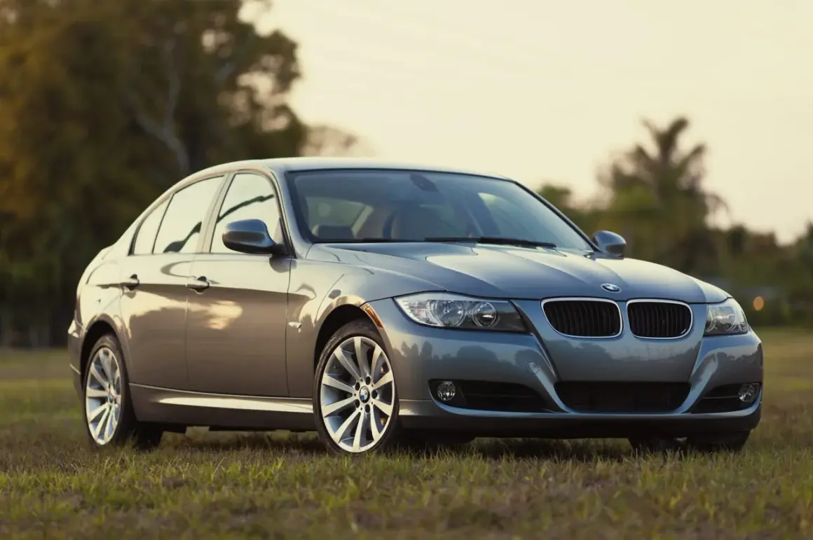 Szary sedan BMW na trawie. Klasyczne rodzaje karoserii, jak ten, są ponadczasowe.