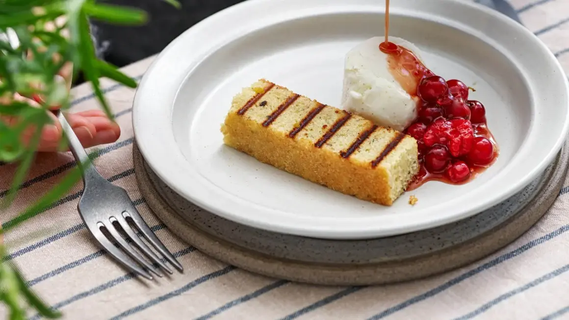 Grillad sockerkaka med vaniljglass, rårörda lingon och en sirap som påminner om ett kardemumma recept.