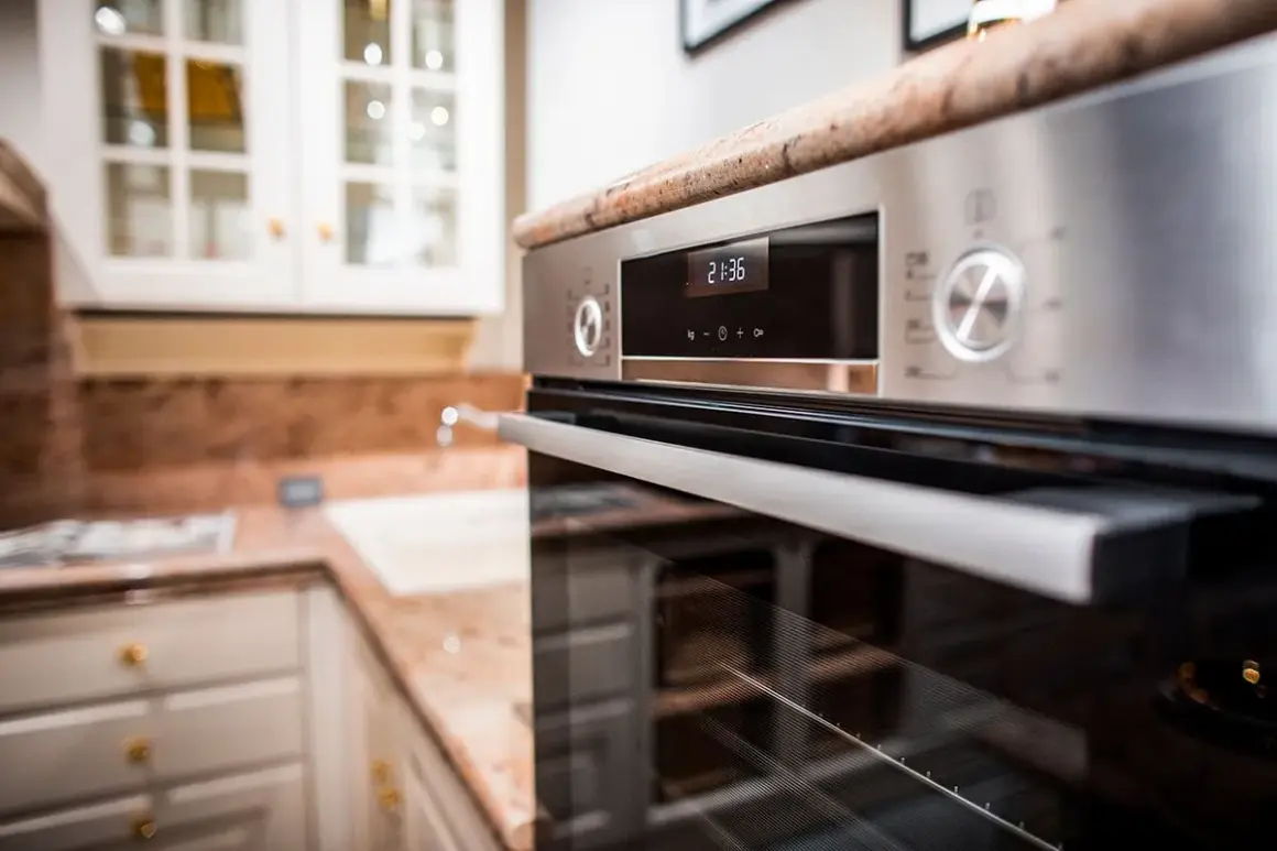 Forno moderno in acciaio inossidabile, con display digitale e manopole. Ideale per chi cerca come pulire il forno incrostato senza fatica.