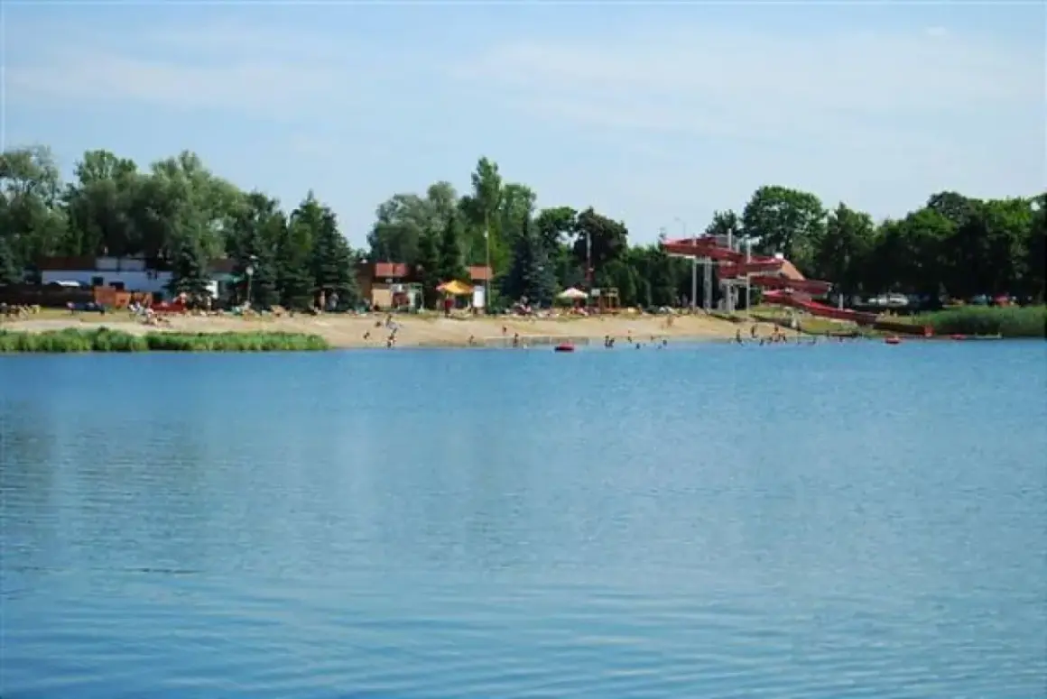Letnia plaża z czerwonymi zjeżdżalniami wodnymi nad jeziorem, popularne miejsce wypoczynku, Morskie Oko Wrocław.