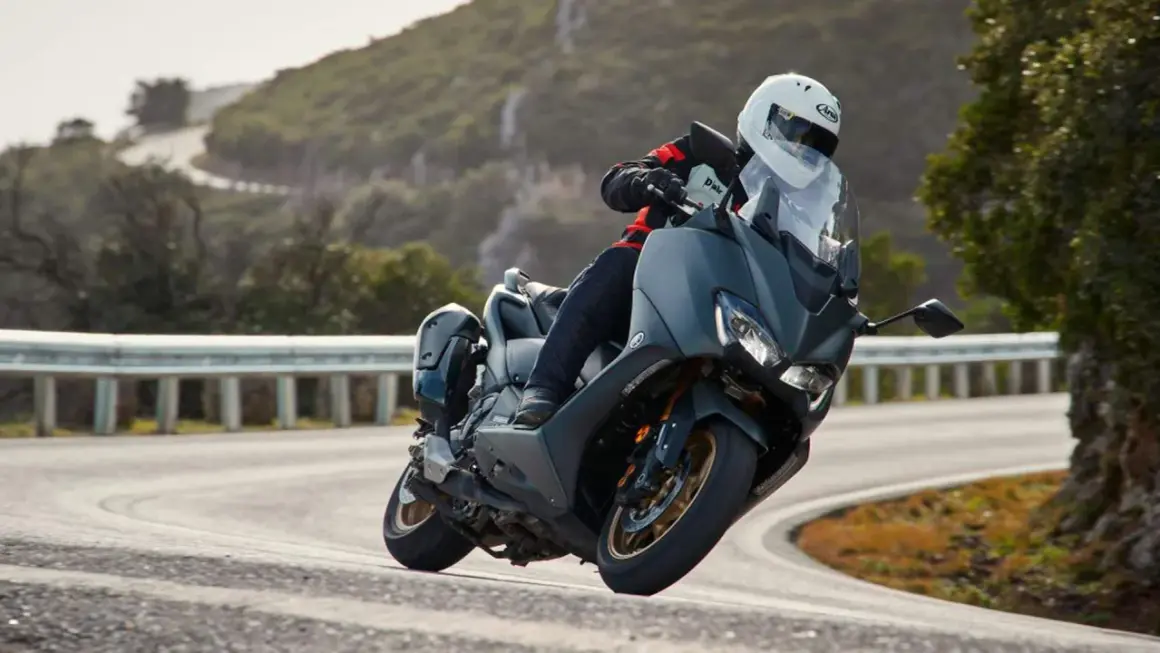 Motociclista en TMAX, disfrutando de la velocidad máxima en una carretera sinuosa.