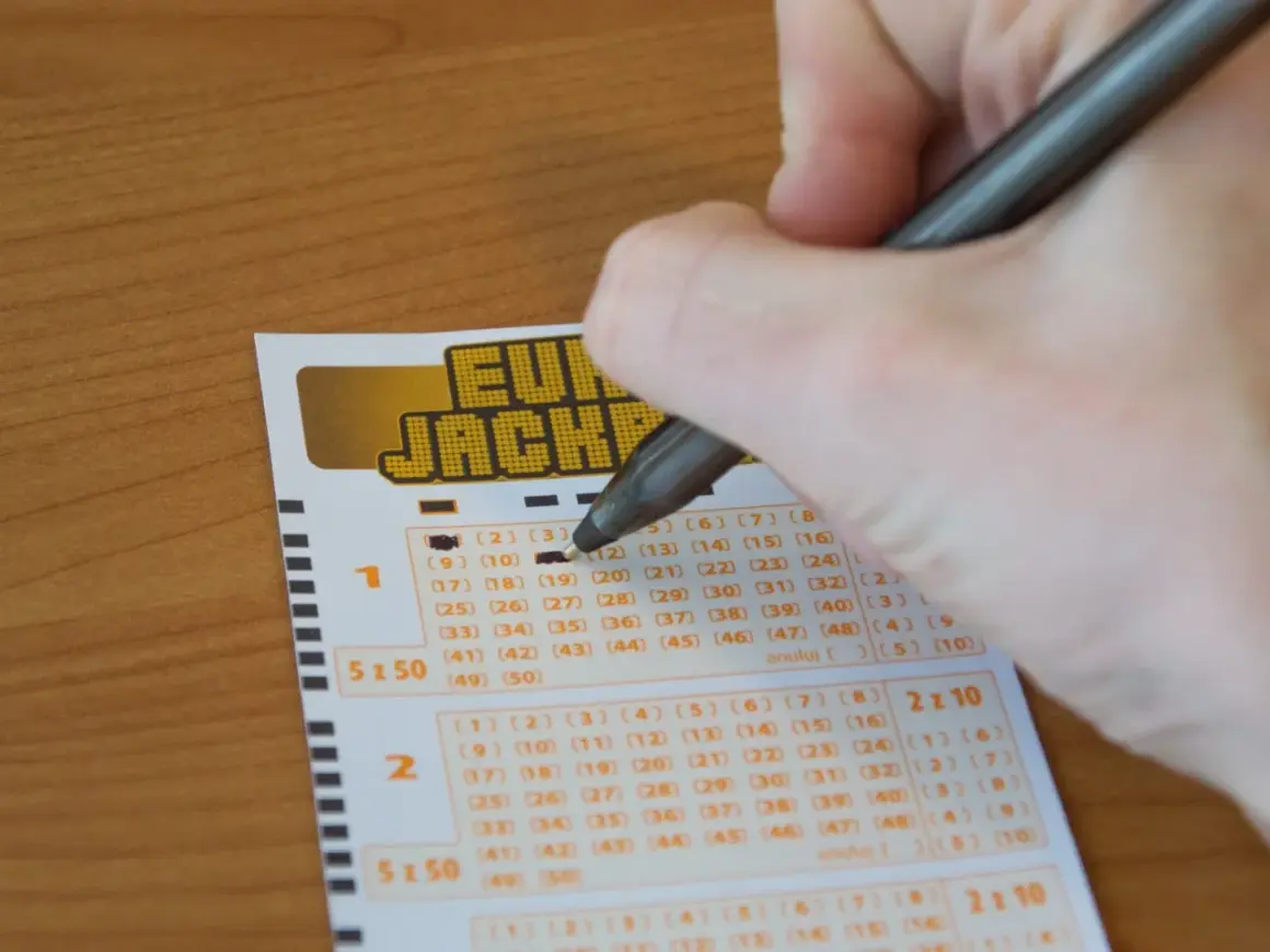 Ręka zaznacza liczby na kuponie Eurojackpot. Czy można grać w Eurojackpot mieszkając w Polsce, ale kupując los w Niemczech?