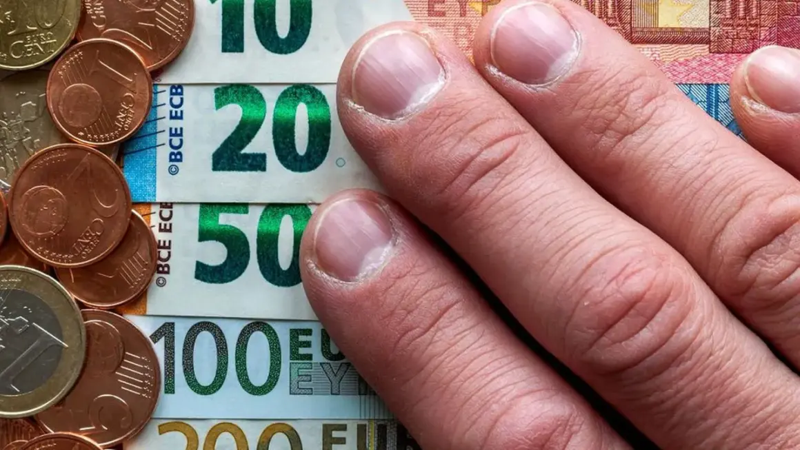 Dłonie na banknotach 10, 20, 50, 100 euro i monetach. To archiwum kursu euro.