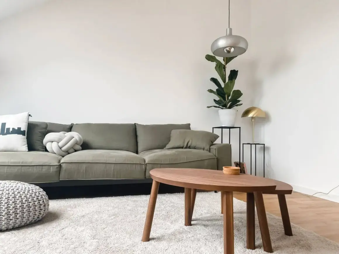 Grüne Couch, die durchgesessen ist, aber mit neuen Kissen und einem Pouf wirkt sie frisch. Ideen für couch durchgesessen aufpolstern selber machen.