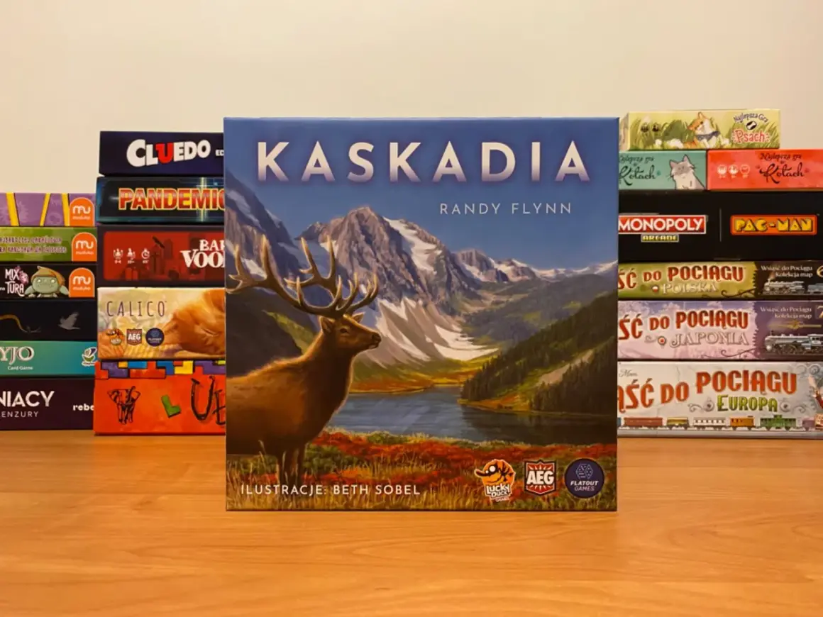 Gra planszowa Kaskadia z jeleniem na okładce, otoczona innymi grami jak Cluedo, Pandemic, Monopoly.