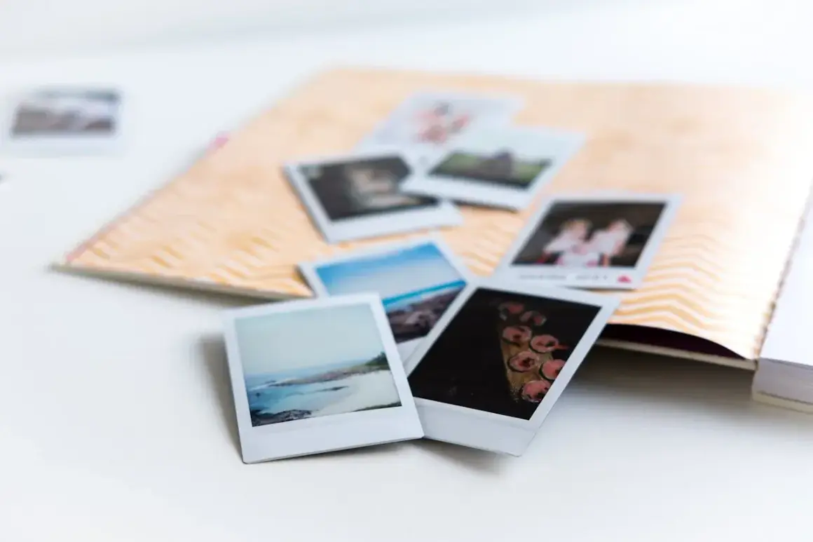 Zdjęcie 10x15 to format, który idealnie pasuje do albumu. Kilka polaroidów leży na ozdobnej karcie.