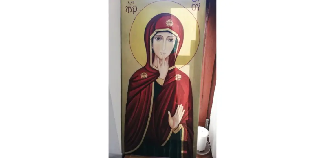 Ikona Matki Bożej w głębokich, maryjnych kolorach. Czerwień płaszcza i złota aureola podkreślają jej majestat.