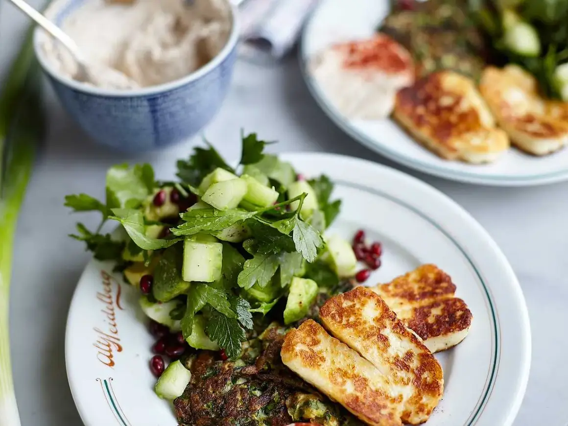 En härlig tallrik med stekt halloumi, en fräsch sallad med gurka och granatäpple, samt en grön röra. Ett perfekt halloumi recept för en lätt måltid.
