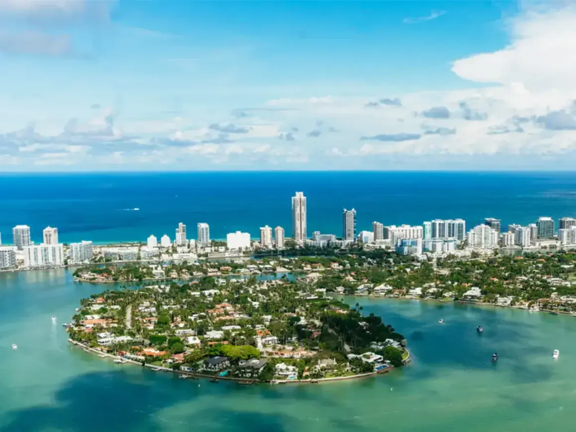 Piękna miami pogoda, błękitne niebo i turkusowa woda otaczają wyspy z luksusowymi willami i drapaczami chmur.