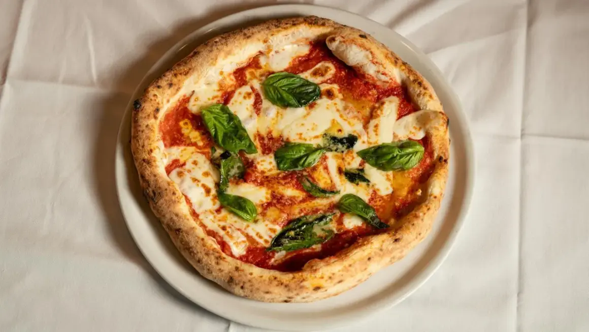Margherita pizza z bazylią i mozzarellą. Czy wiesz, że ciekawostki o pizzy są równie pyszne jak ona sama?
