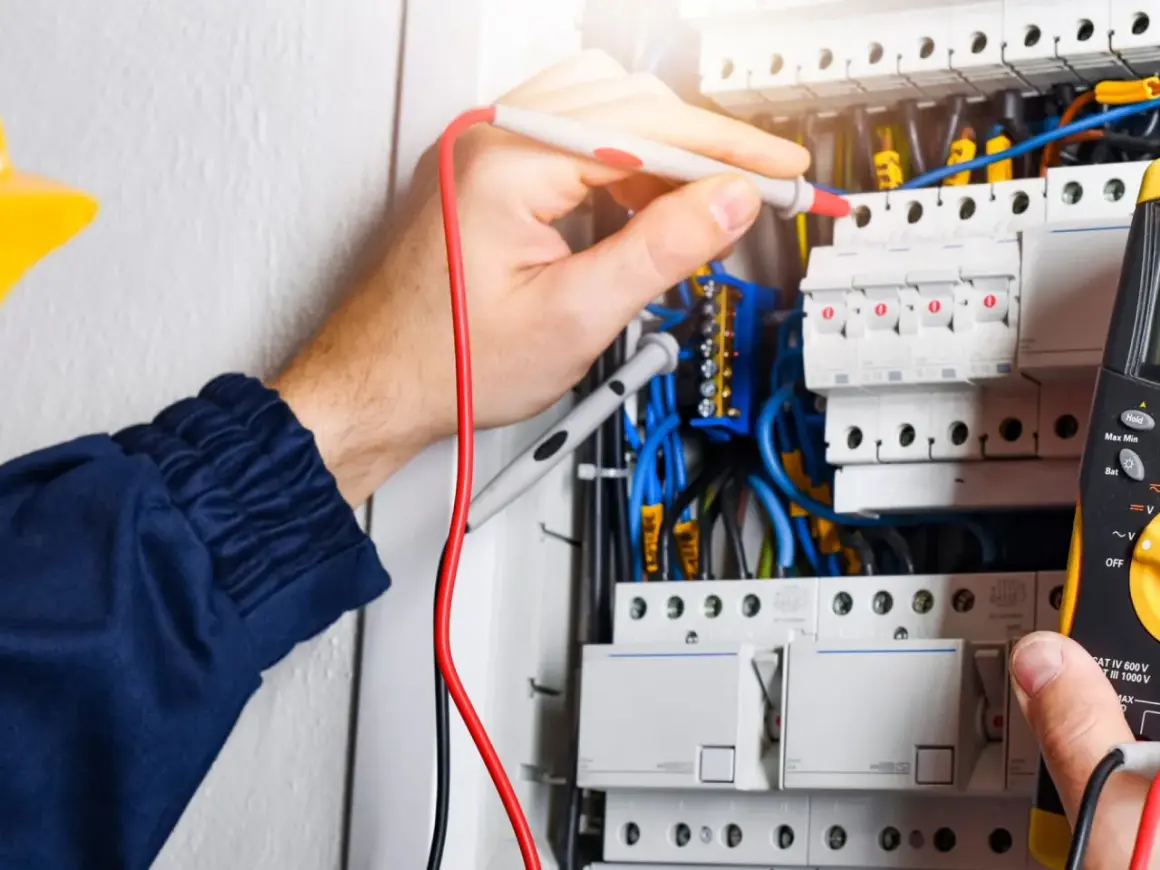 Elektryk sprawdza instalację. W elektryce "L" to przewód fazowy, kluczowy dla przepływu prądu.