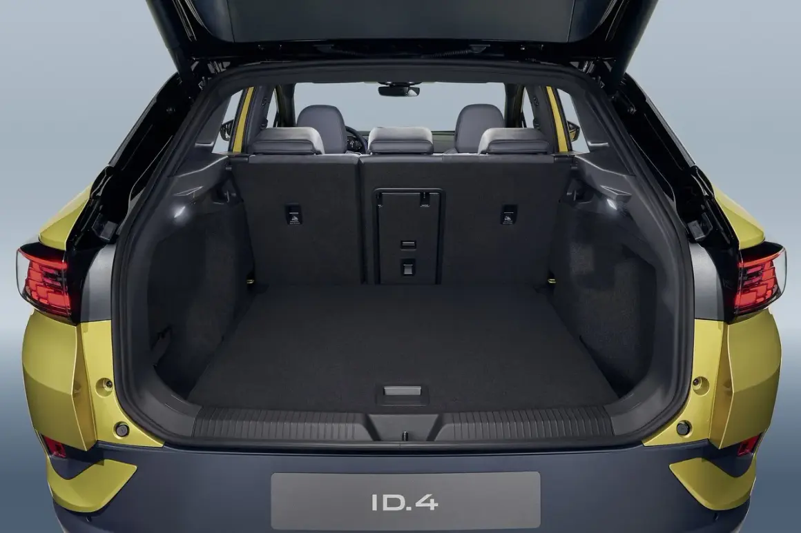 Vue du coffre ouvert d'une Volkswagen ID.4 jaune. Le volume du coffre est spacieux, prêt à accueillir vos bagages pour un long voyage.