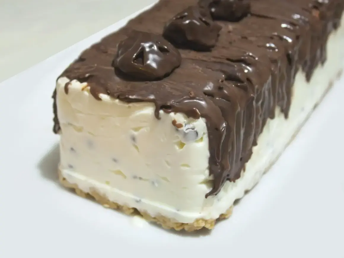 Pyszne lody cassate w czekoladzie, z kawałkami czekolady w środku, na kruchym spodzie.