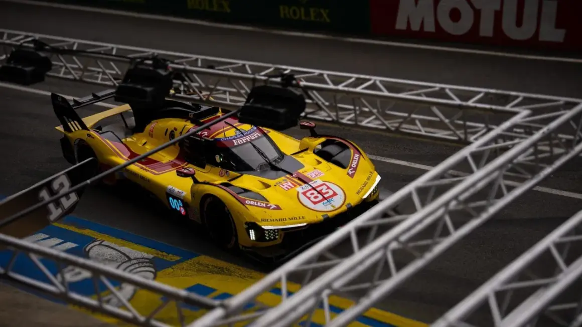 Żółto-czerwony bolid Ferrari z numerem 83 na torze podczas wyścigu Le Mans 24h.