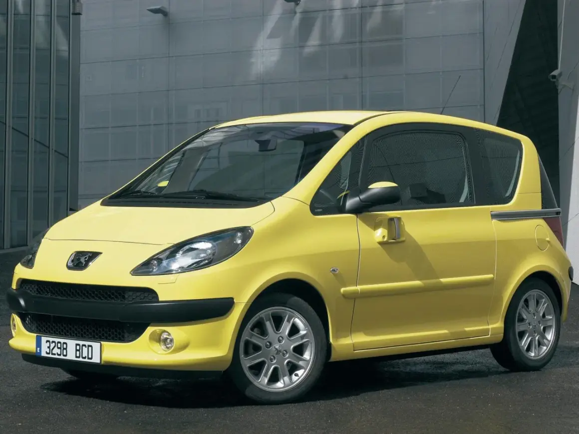 Żółty Peugeot 1007 z przesuwnymi drzwiami na tle nowoczesnego budynku.