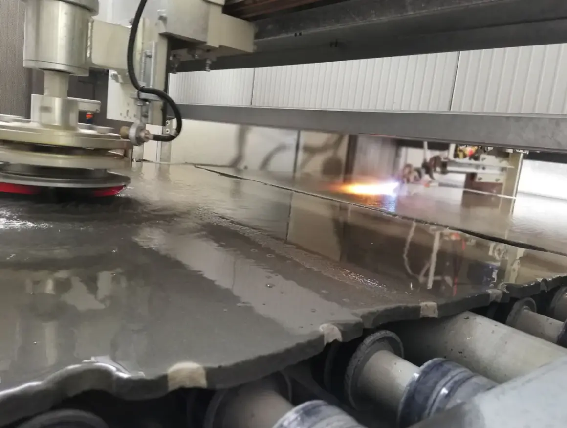 Macchina industriale esegue la fiammatura marmo, creando una superficie ruvida e antiscivolo.