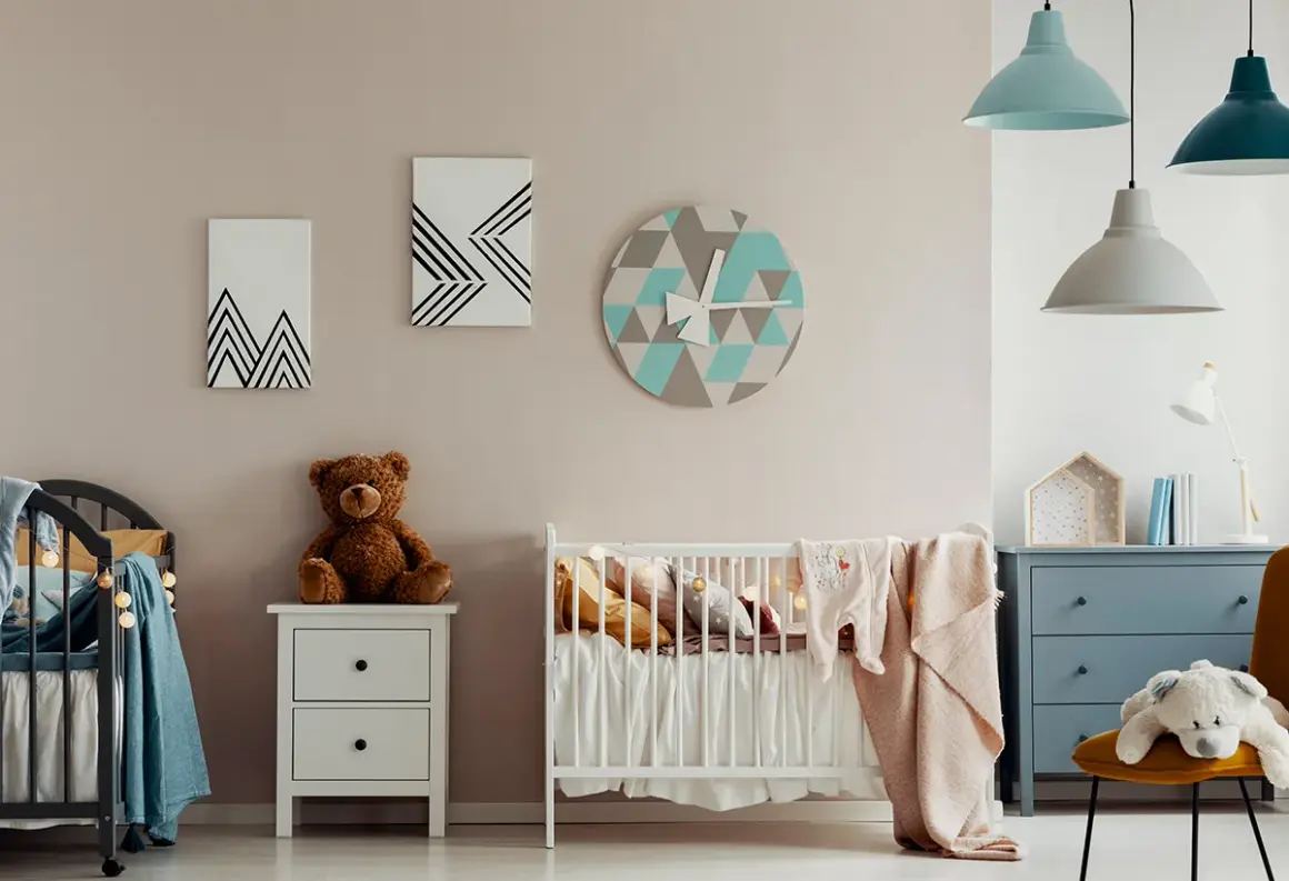 Chambre de bébé avec berceau, peluche et horloge géométrique. Une belle idée de diy deco bebe pour une chambre douce et moderne.