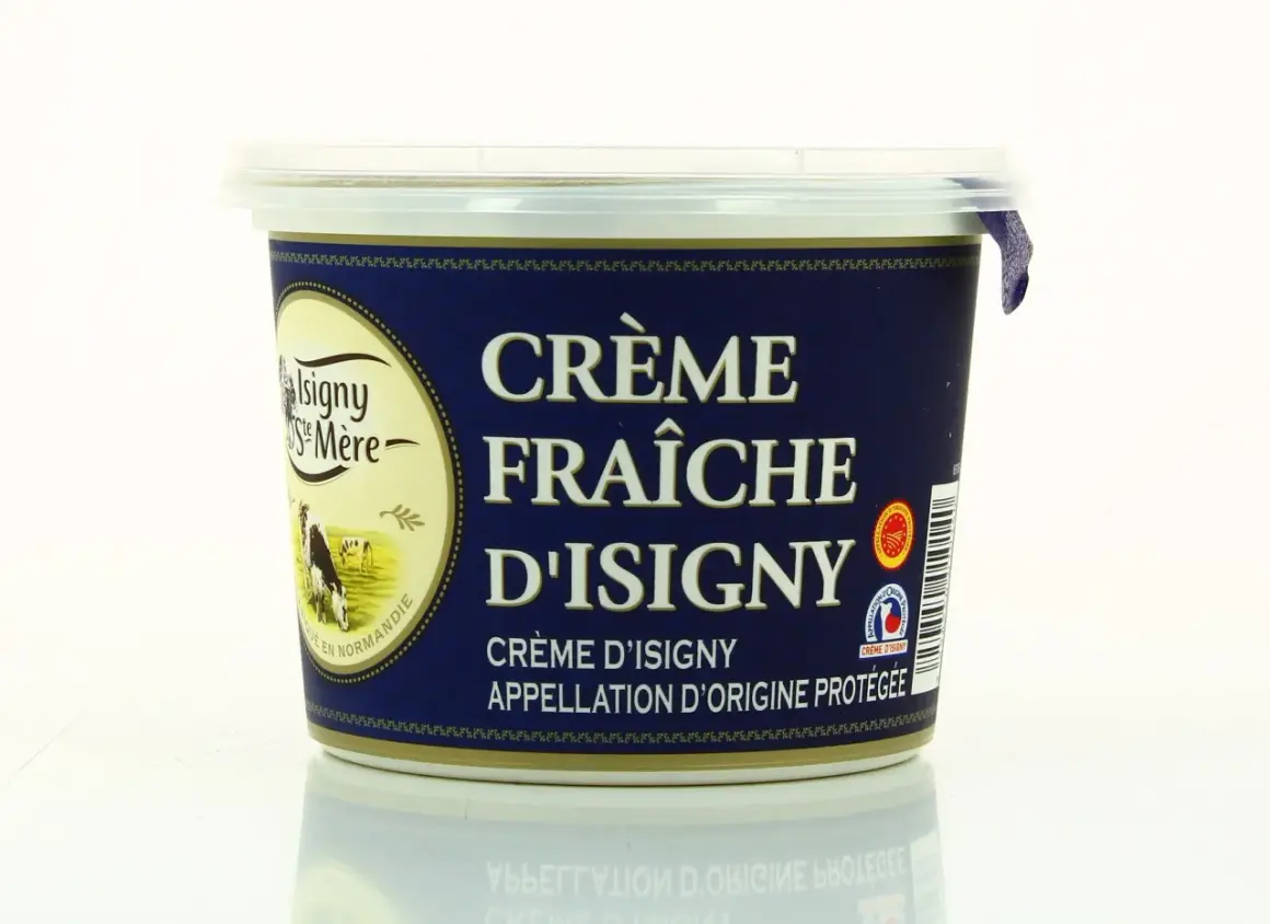 Un pot de crème fraîche d'Isigny, avec une vache dans un pré sur l'étiquette. La crème d'Isigny est une spécialité normande.