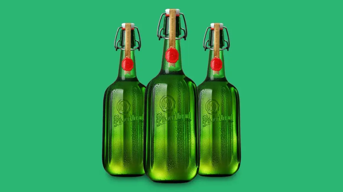 Drei grüne Flaschen Pilsner Urquell mit Bügelverschluss und rotem Siegel stehen nebeneinander.