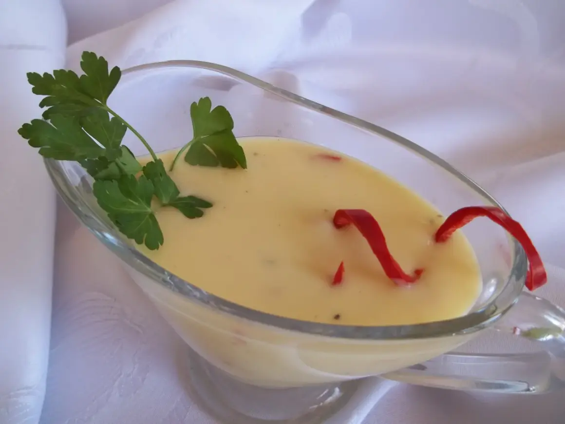 Kremowy sos cytrynowy do ryby, ozdobiony natką pietruszki i papryczką chili.