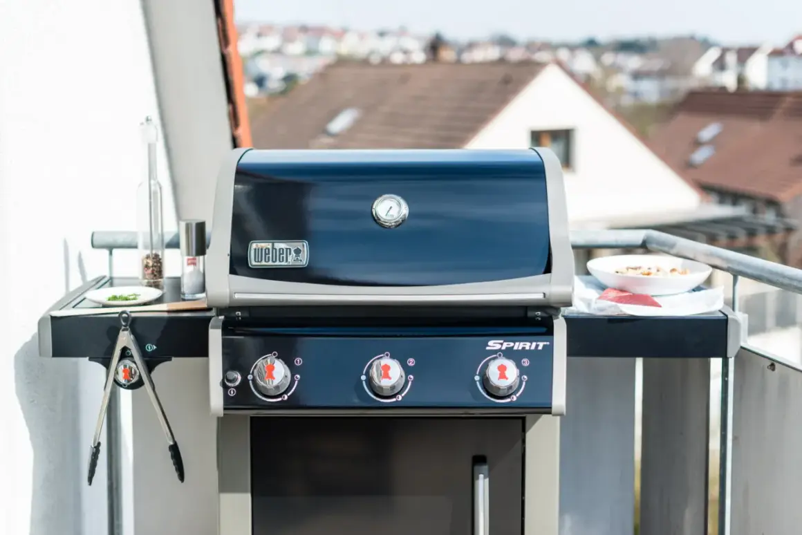 Weber Gasgrill auf dem Balkon: Grillen erlaubt! Mit Fleisch und Gewürzen bereit für den Genuss.
