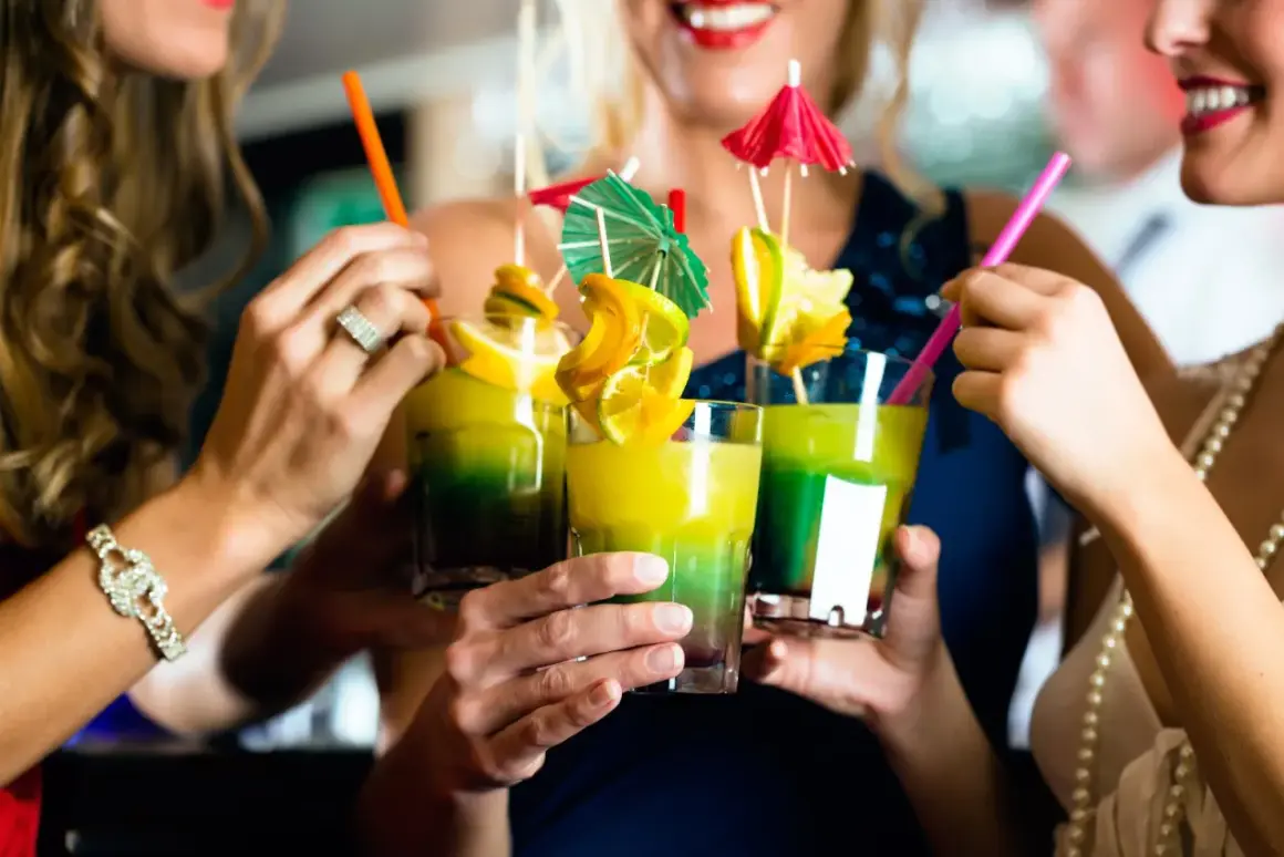 Amici brindano con cocktail colorati, un assaggio di divertimento nelle discoteche di Barceloneta.