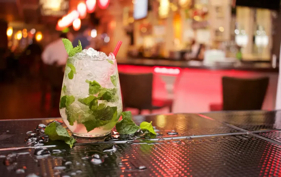 Orzeźwiający koktajl z rumem do mojito, lodem i miętą na barze.