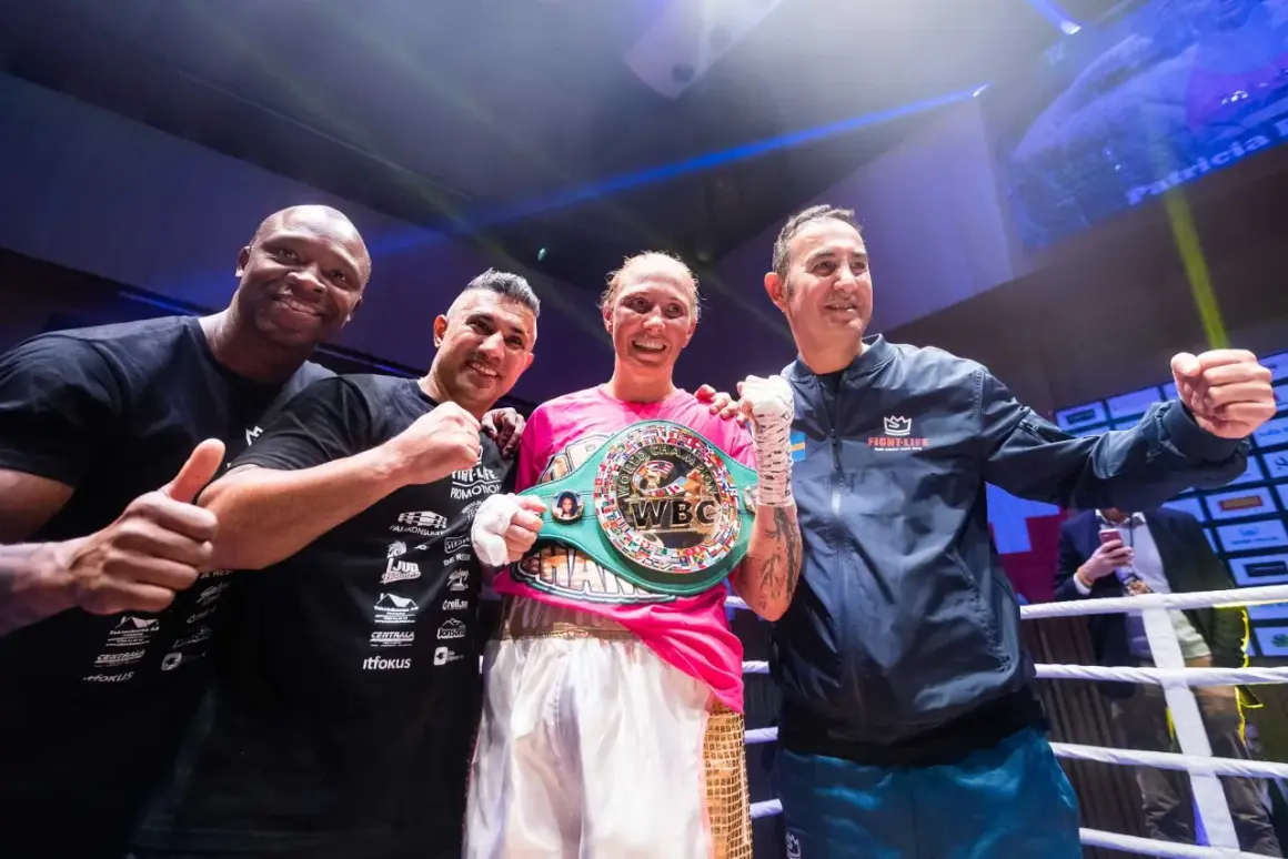 Patricia Berghult firar sin seger med sitt team, bärandes ett WBC-mästarbälte.