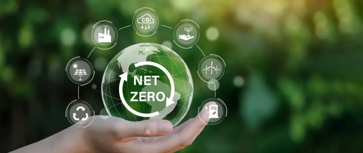 Dłoń trzymająca Ziemię z napisem "NET ZERO", otoczoną ikonami symbolizującymi zrównoważony rozwój i neutralność klimatyczną.