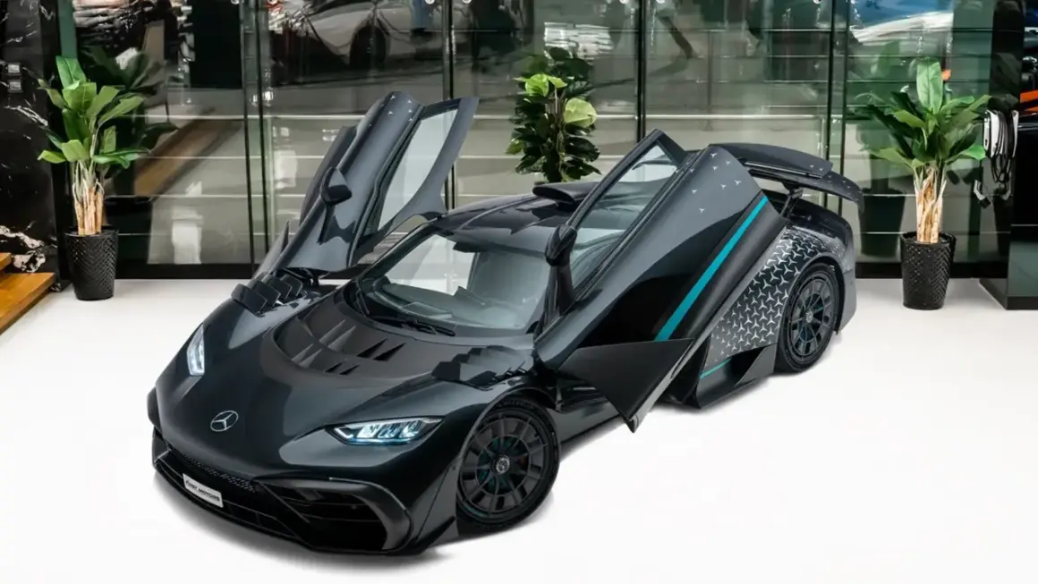 Szary Mercedes-AMG ONE z otwartymi drzwiami, prezentujący swoje futurystyczne linie i sportowy charakter.