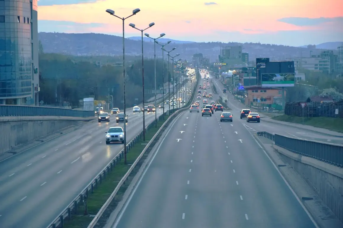 Ruch samochodowy na wielopasmowych autostradach i drogach ekspresowych o zmierzchu.