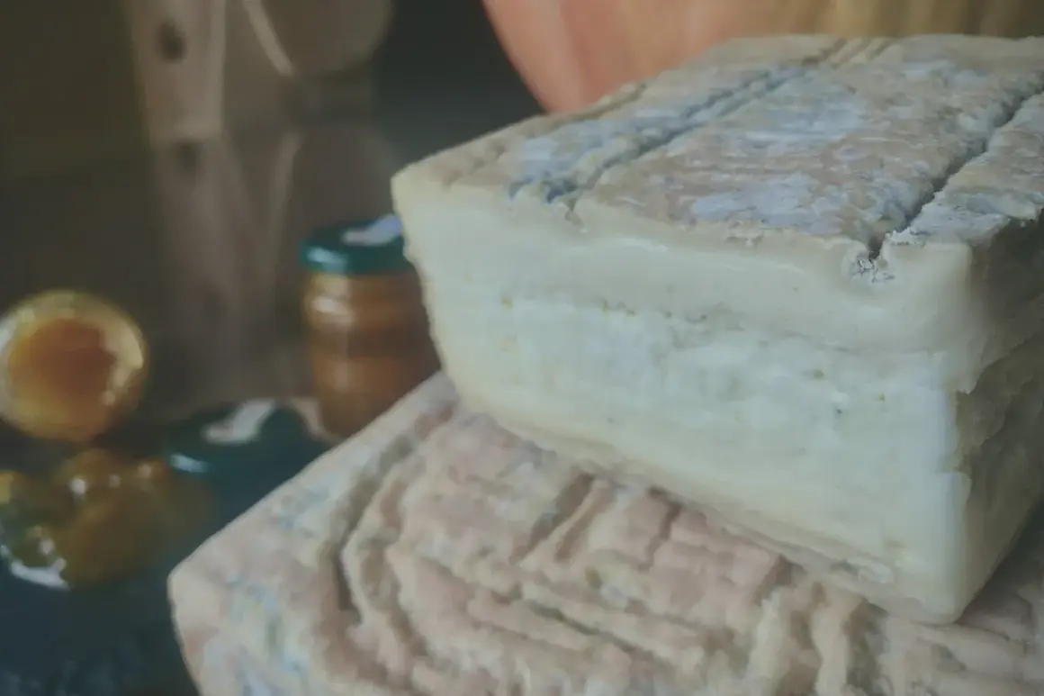 Formaggio Taleggio, con la sua crosta fiorita e la pasta morbida, racconta la sua origine bergamasca. Accanto, marmellata e confettura.