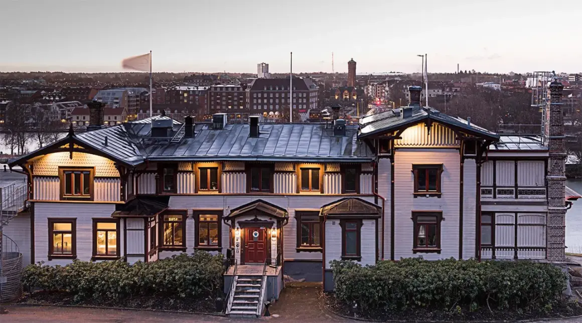 Vacker villa med utsikt över Trollhättan. Albert, en historisk byggnad, badar i kvällsljus.
