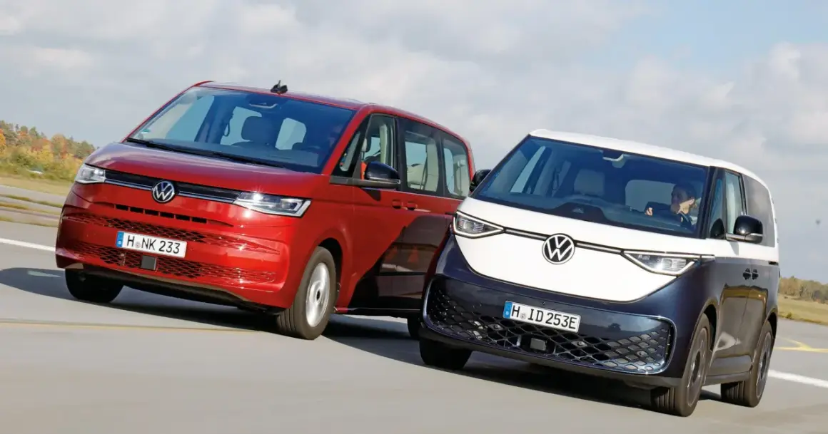 Dwa minivany Volkswagen: czerwony i dwukolorowy, jadące po drodze.