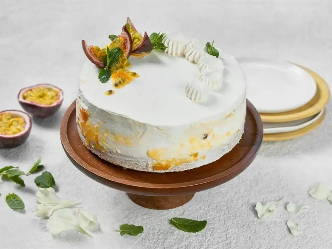 En vacker vegansk tårta med passionsfrukt och mynta, dekorerad med små maränger.