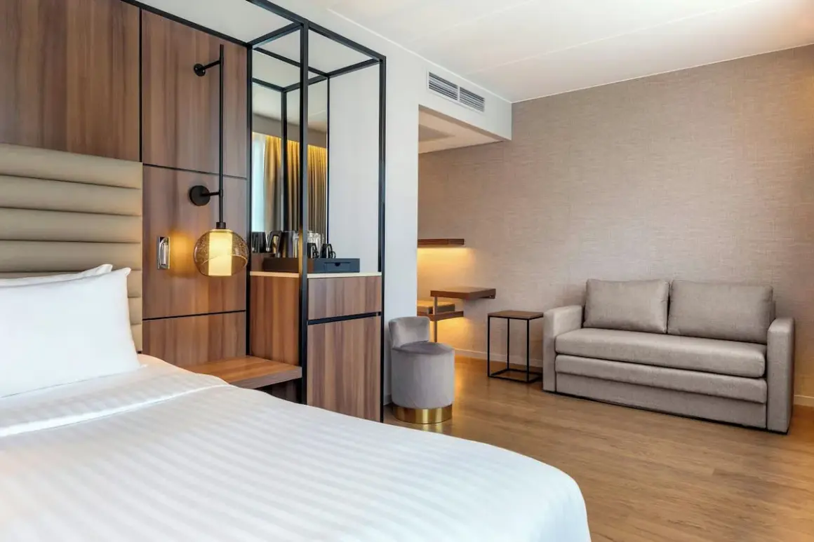 Ett modernt hotellrum på AC Hotel Solna med en bekväm säng, soffa och stilren inredning.