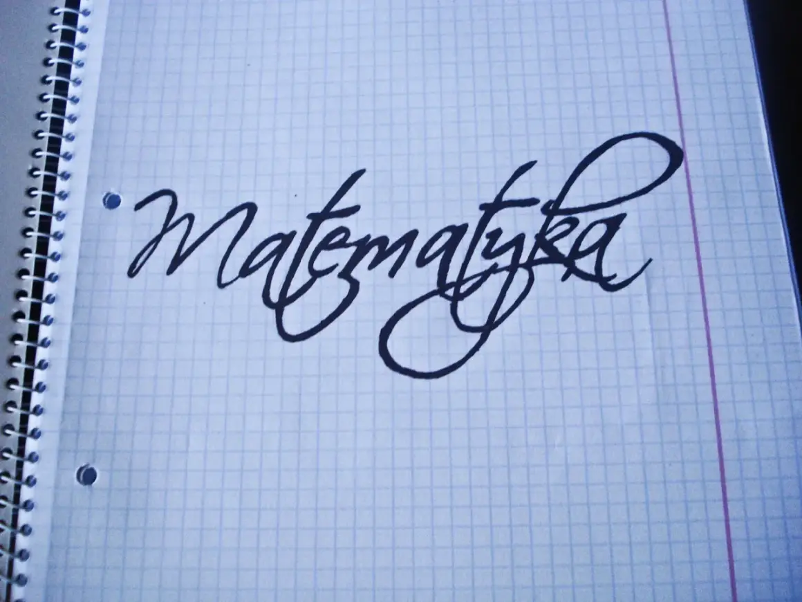 Napis "Matematyka" wykonany ozdobnym pismem odręcznym na kartce w kratkę.
