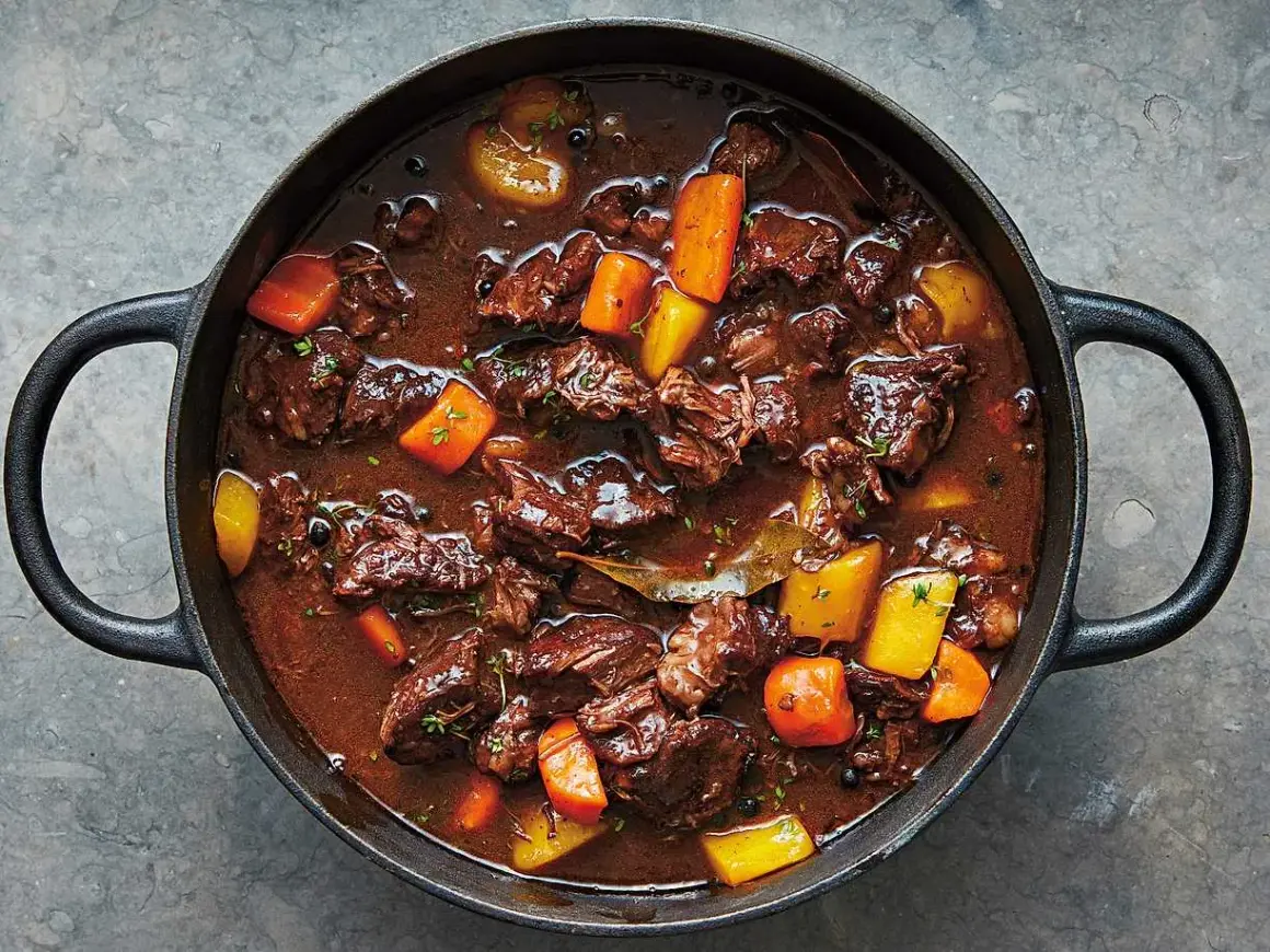 En mustig kalops i gjutjärnsgryta, perfekt för ett klassiskt kalops recept. Kött, morötter och potatis i en mörk sås.
