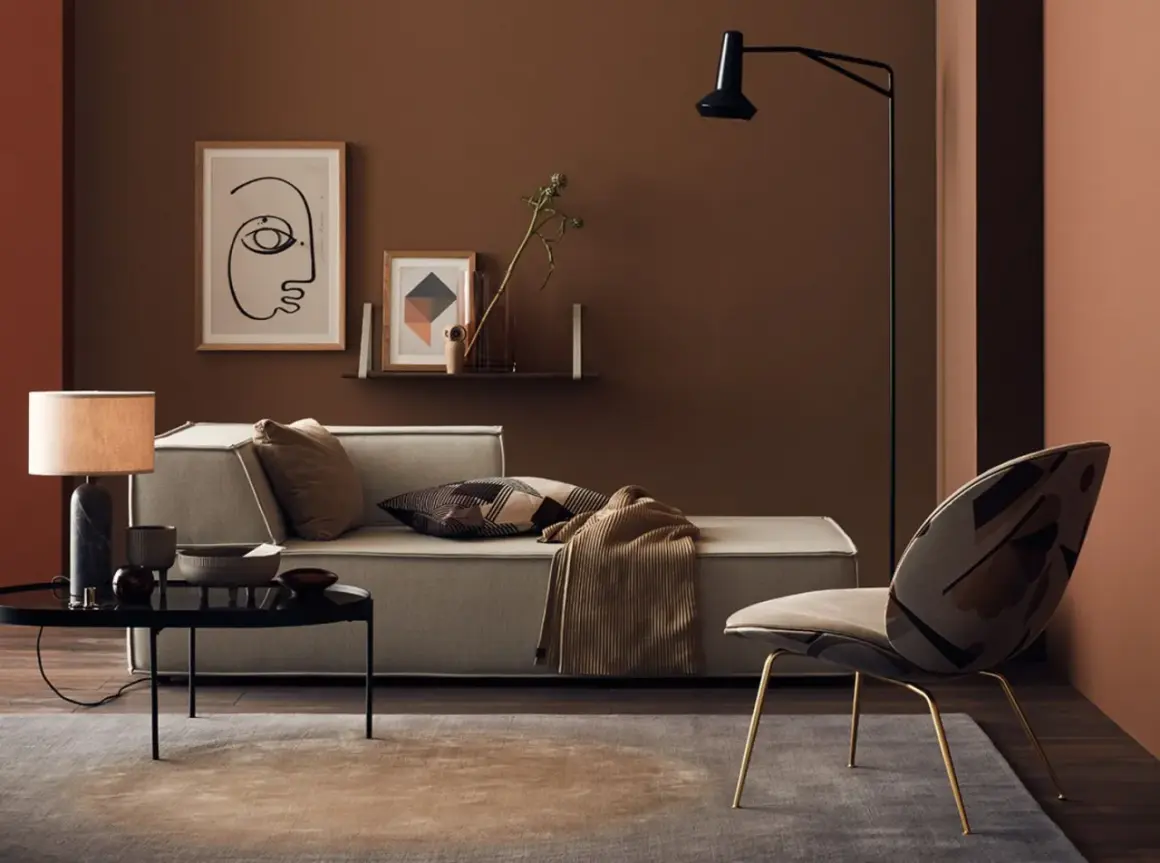 Gemütliches Wohnzimmer mit einer braunen Wand, einem hellen Sofa, einem auffälligen Sessel und einem Couchtisch.