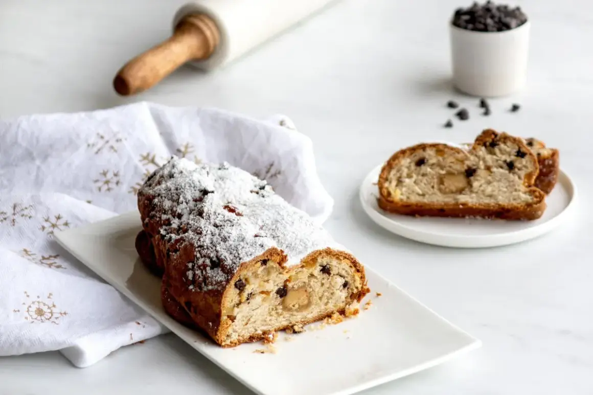 Un délicieux gâteau de Noël, saupoudré de sucre glace, semble avoir été volé, avec une part coupée et servie sur une assiette.